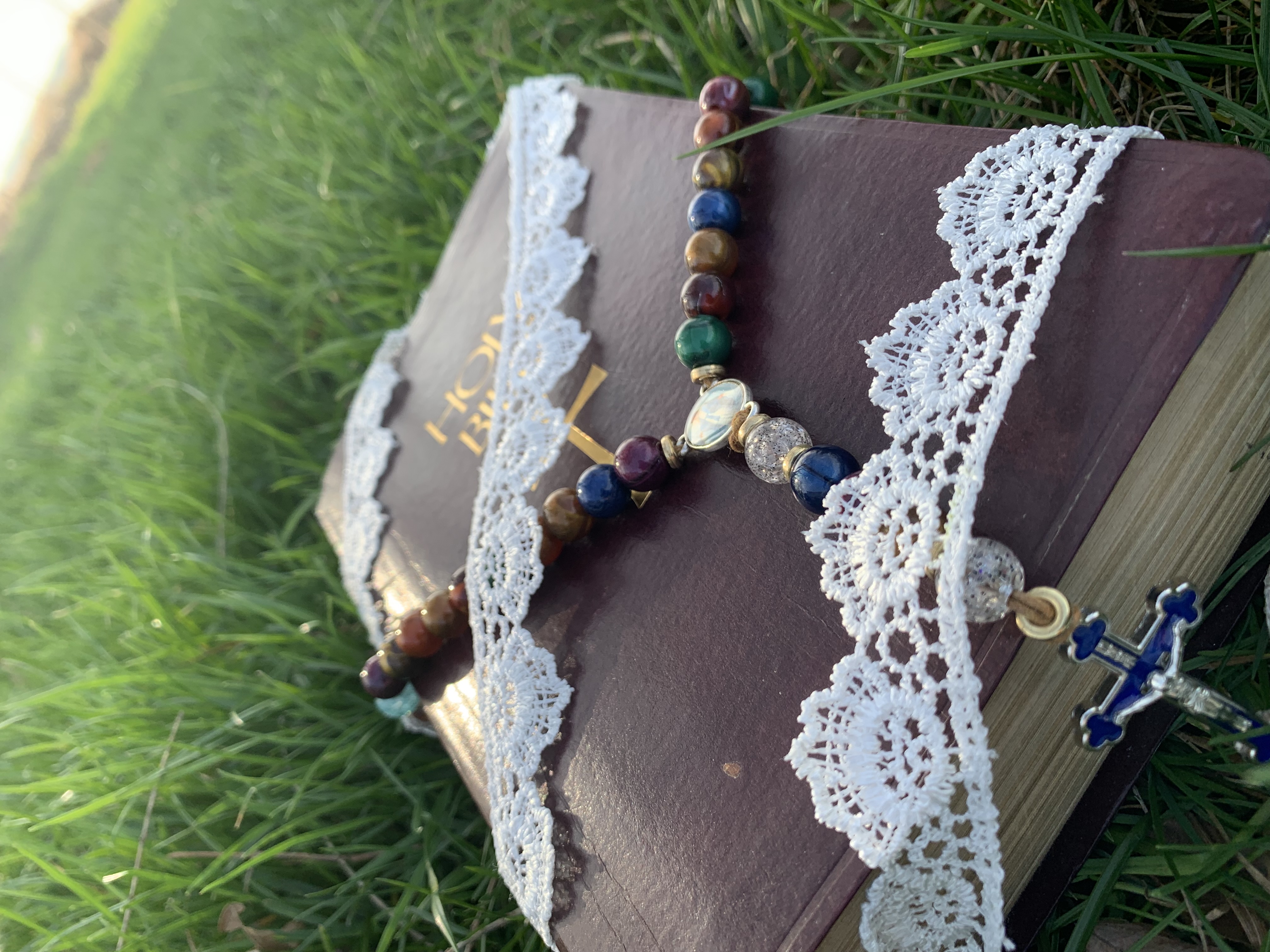 A picture of the bible and rosary outside.